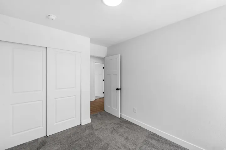 Spacious room featuring gray textured carpeting, white walls, and bright white trim