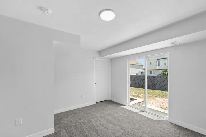 Spacious room featuring neutral carpeting and light-colored walls