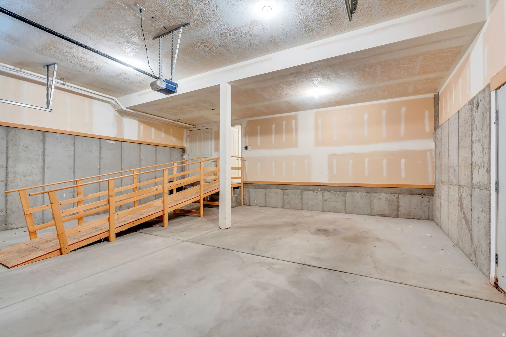 Spacious concrete-floor interior with a wood-framed ramp and concrete block lower walls