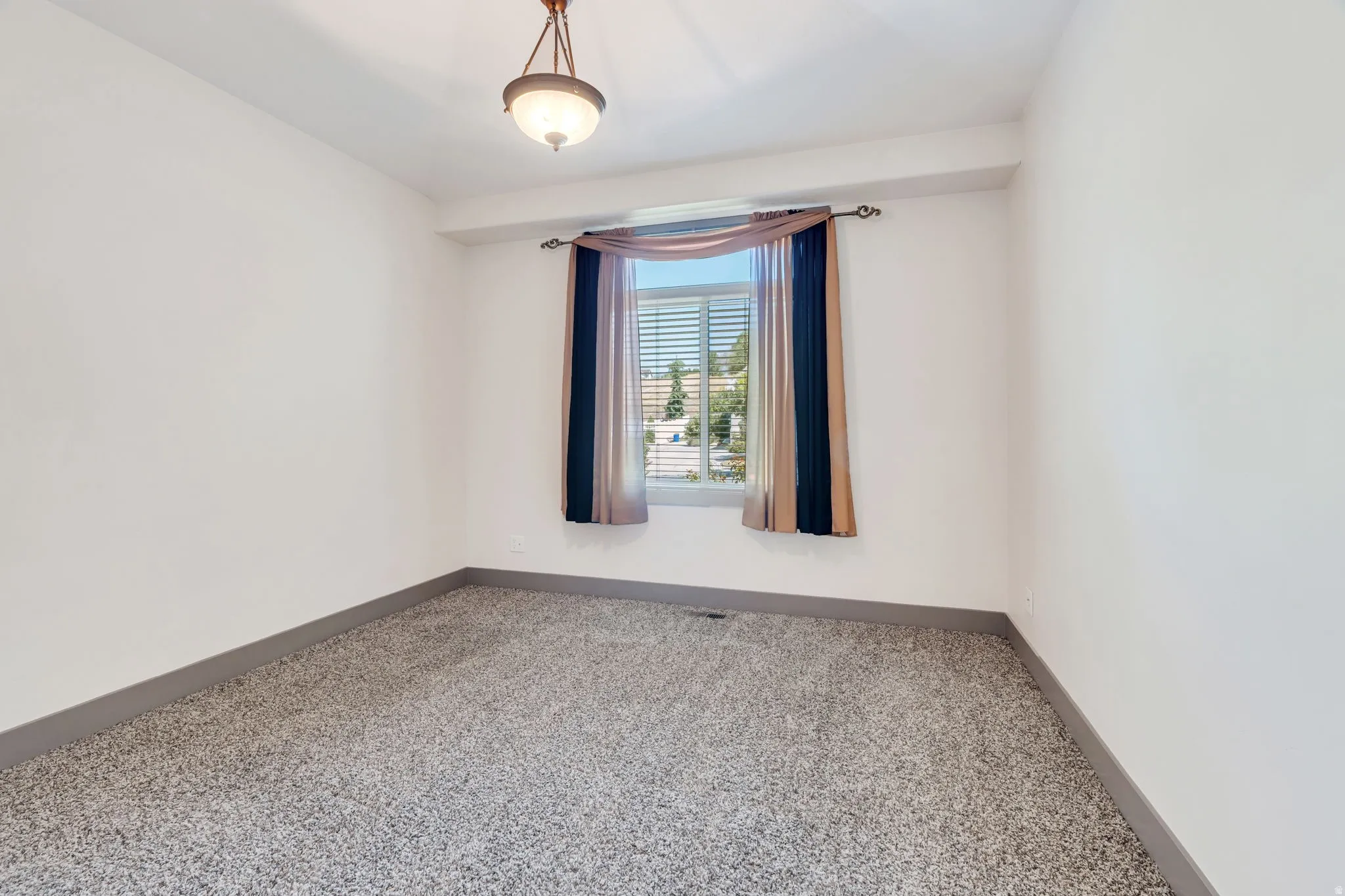 Interior room featuring light-colored walls and grey speckled carpeting