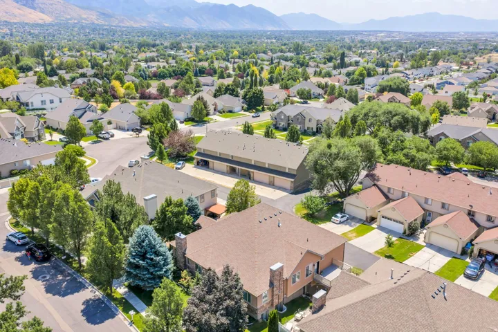 Expansive neighborhood setting featuring a variety of residential structures with pitched roofs, mature trees, and landscaped yards