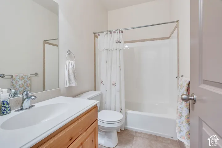 Full bathroom featuring a single vanity with wood-finish cabinetry, a light-toned countertop, and an integrated sink basin