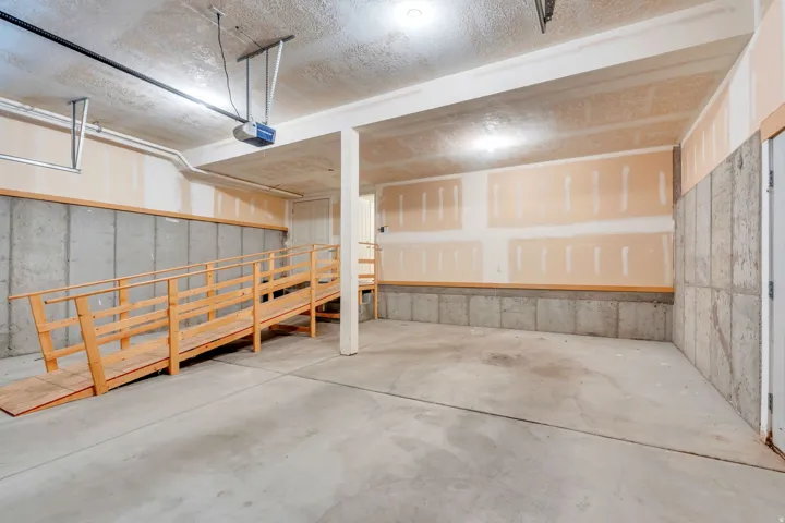 Spacious concrete-floor interior with a wood-framed ramp and concrete block lower walls