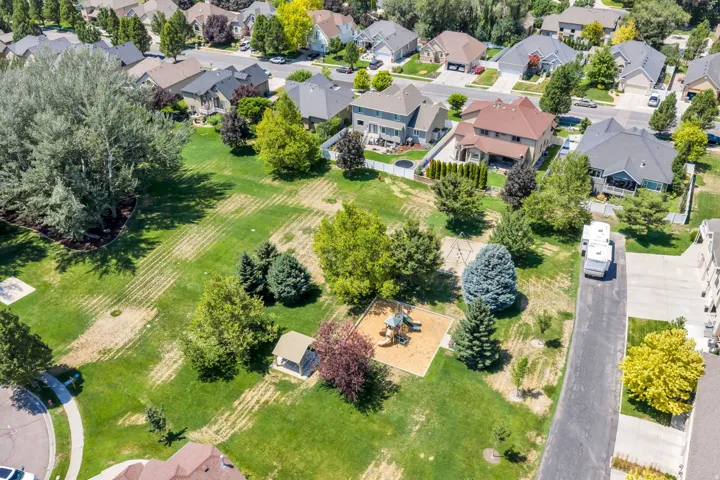 Expansive green space featuring mature trees and a dedicated play area
