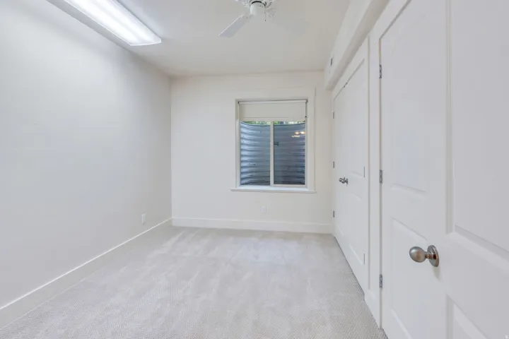Neutral-toned carpeting, white walls, and bright white trim