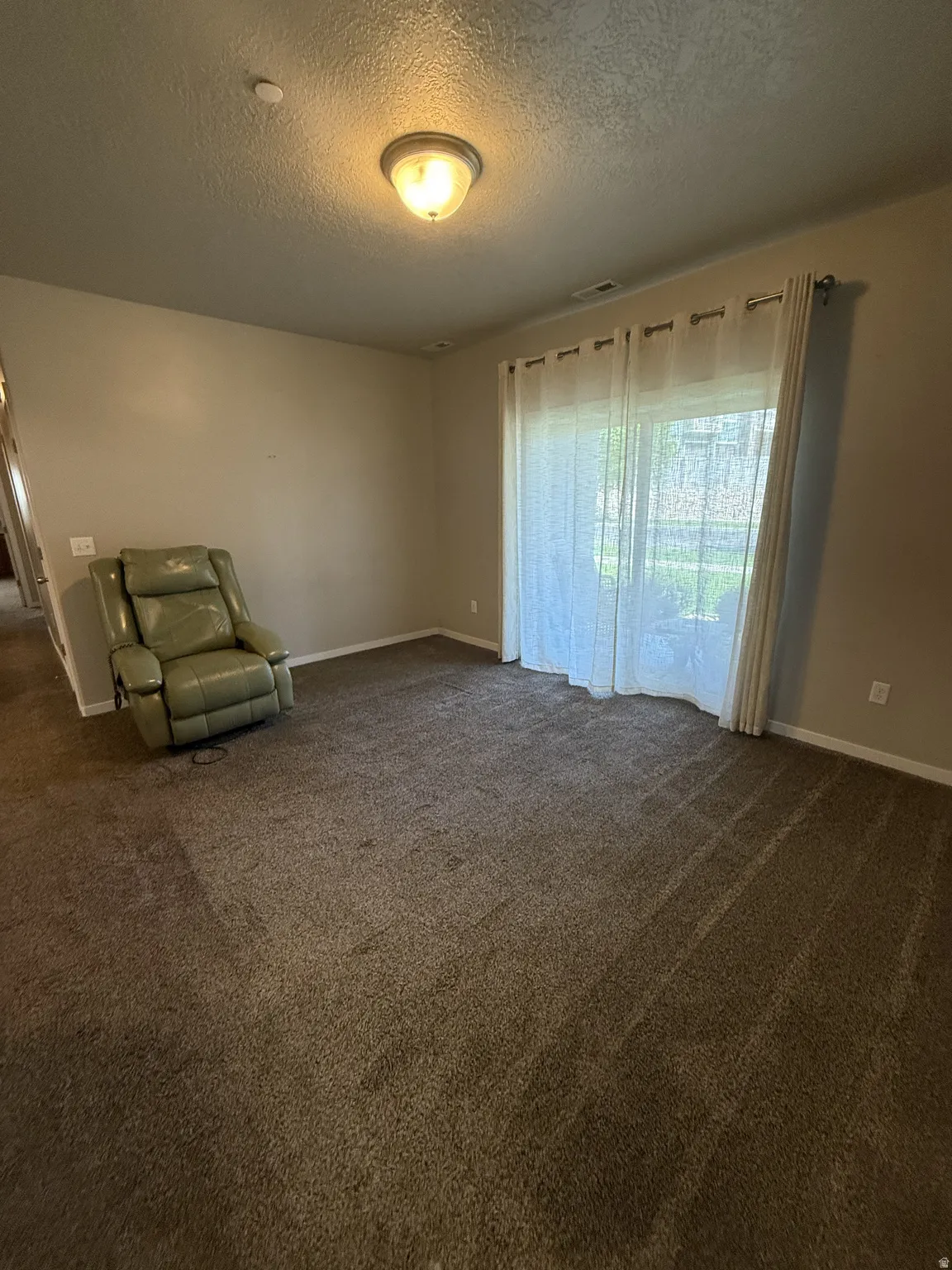 Spacious room featuring neutral carpeting and light-toned walls
