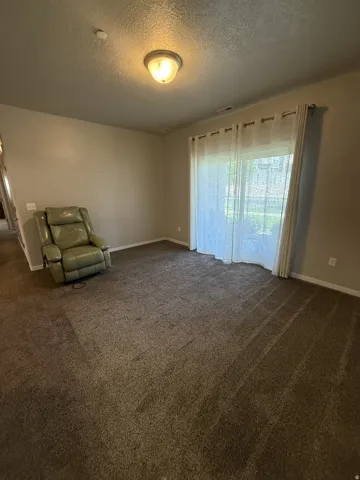 Spacious room featuring neutral carpeting and light-toned walls