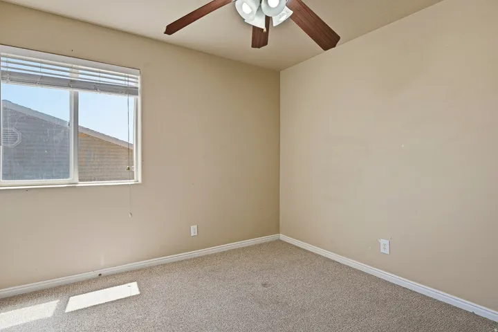 Bedroom featuring neutral wall paint, carpet flooring, a window with blinds, a ceiling fan, and white baseboards