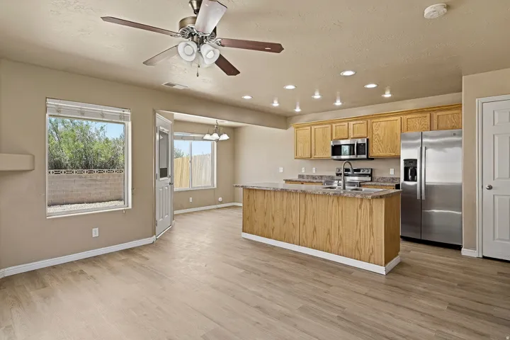 Open-concept living space featuring wood-finish flooring, recessed lighting, and a ceiling fan