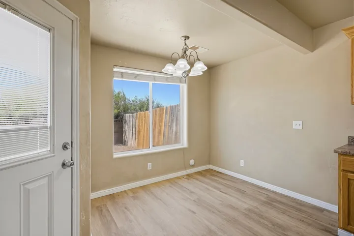 Dining area featuring wood-finish flooring, a multi-pane window, and a decorative ceiling light fixture