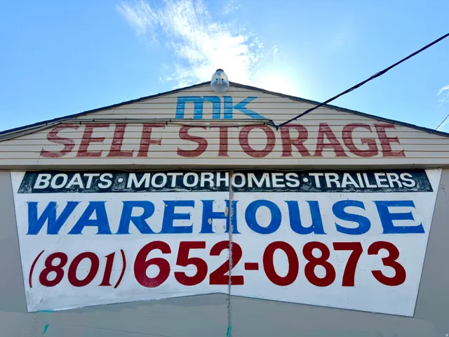 Gable-end commercial signage featuring "MK Self Storage" and "Boats Motorhomes Trailers Warehouse" with contact number