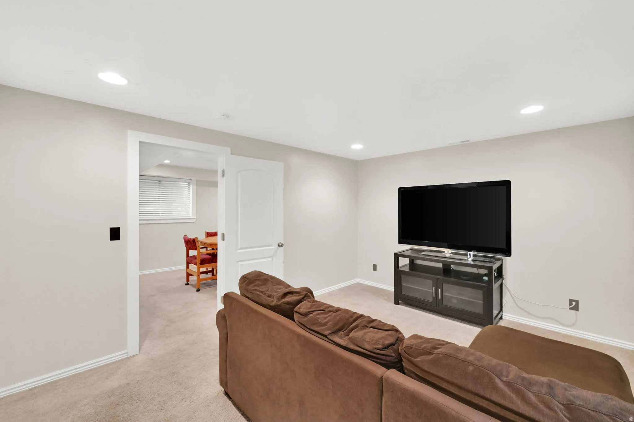 Recessed ceiling lighting, light neutral wall paint, white trim, and light carpeting