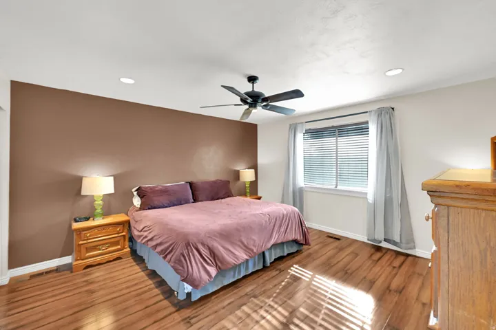 Wood-finish flooring, recessed lighting, ceiling fan, and a window with blinds