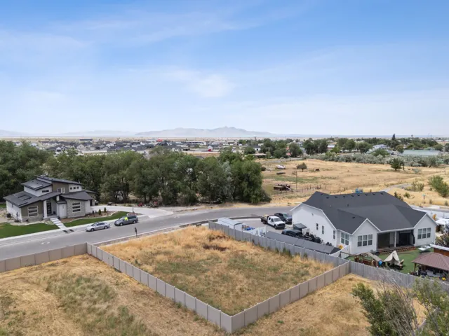 Spacious residential lot featuring a concrete perimeter fence and surrounding natural landscaping