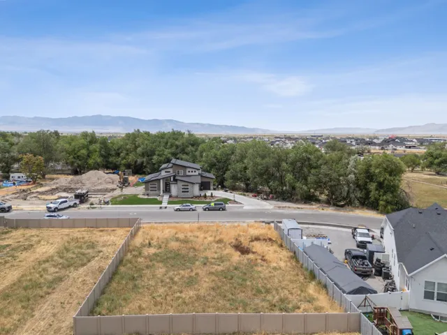 Expansive undeveloped lot with perimeter fencing and distant mountain scenery