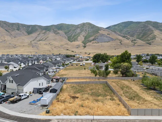 Expansive land parcel featuring a perimeter fence and mountain backdrop