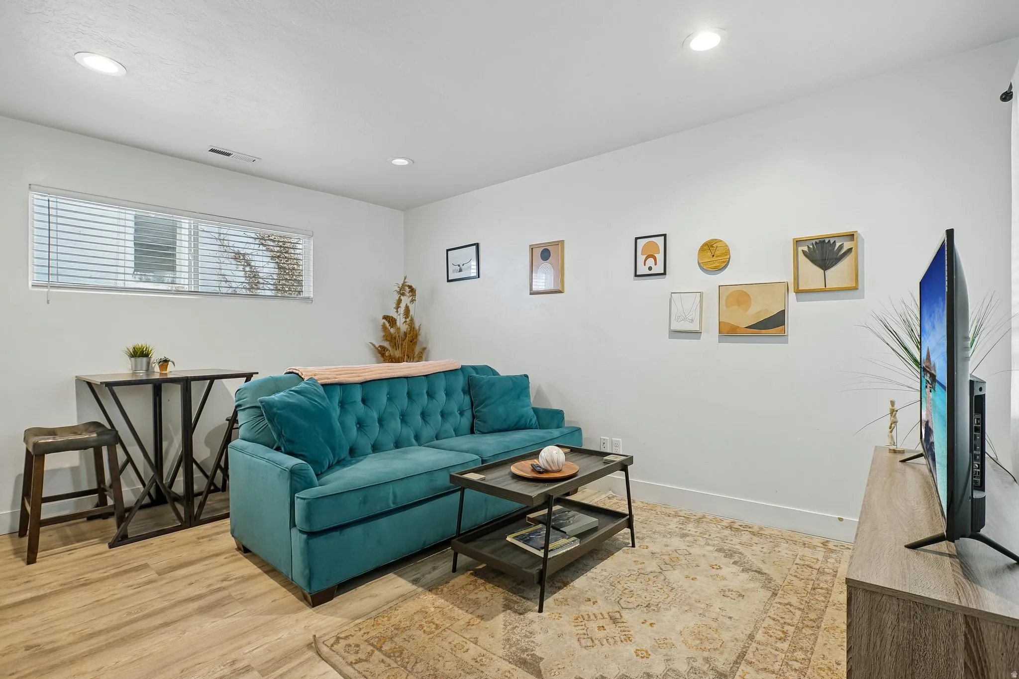 Recessed ceiling lighting, wood-finish flooring, and a window with blinds
