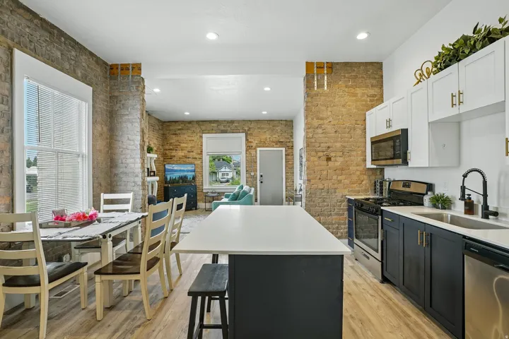 Modern kitchen with white and dark cabinetry, stainless steel appliances, and a central island
