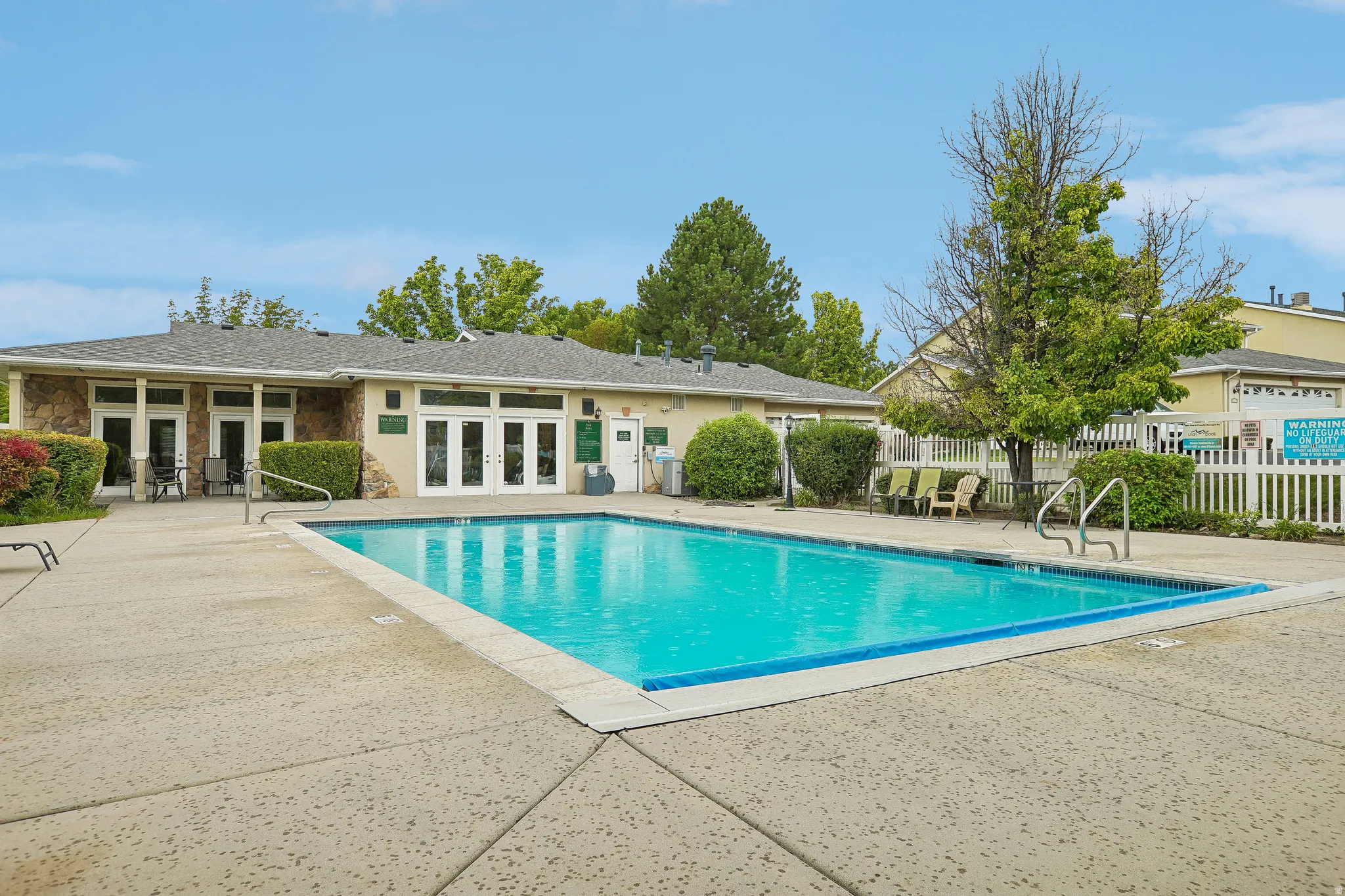Outdoor swimming pool surrounded by a concrete patio