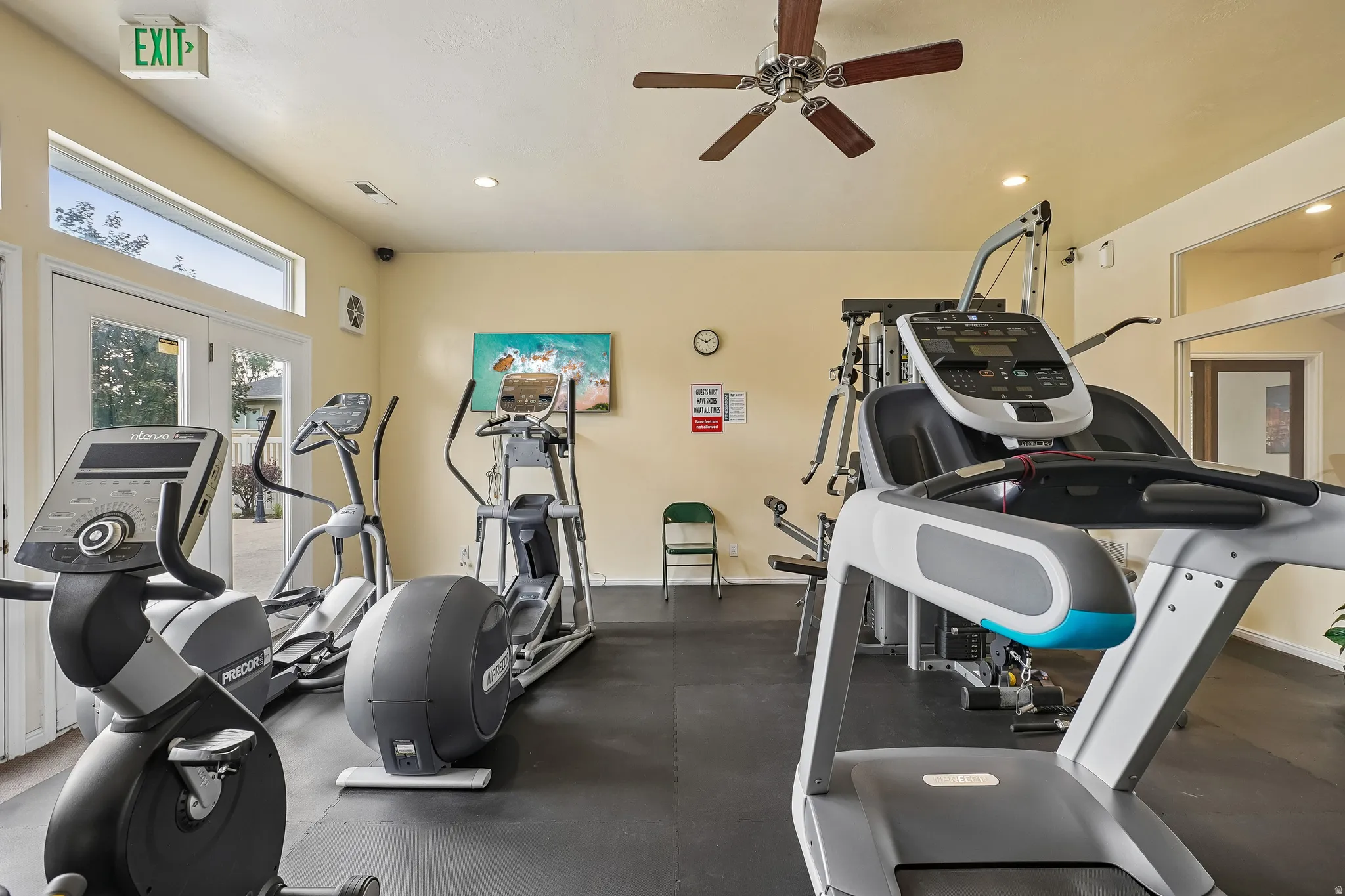 Interior fitness space featuring rubber flooring and a ceiling fan