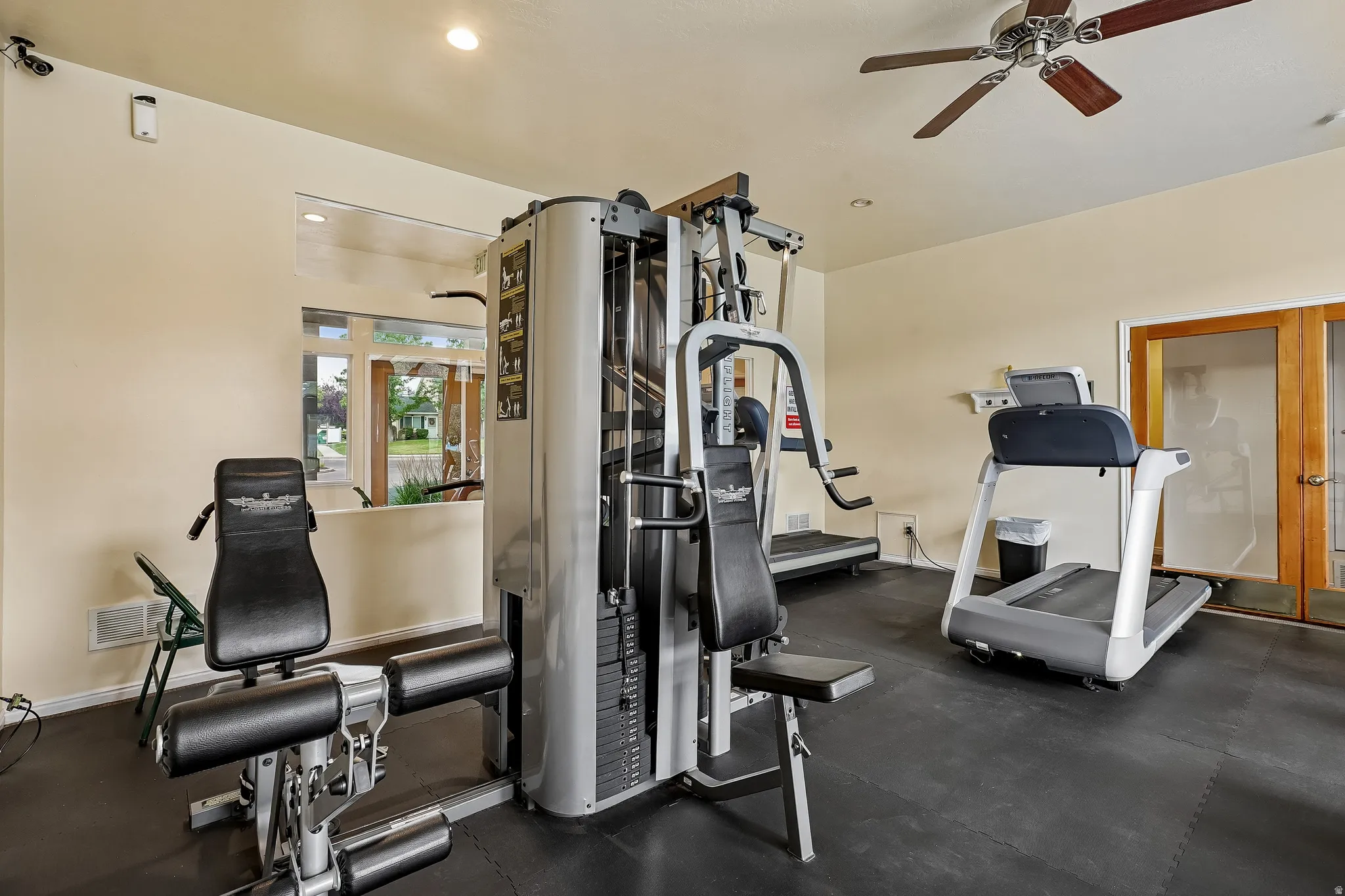 Dedicated exercise room featuring rubber flooring, a ceiling fan, recessed lighting, and a large window