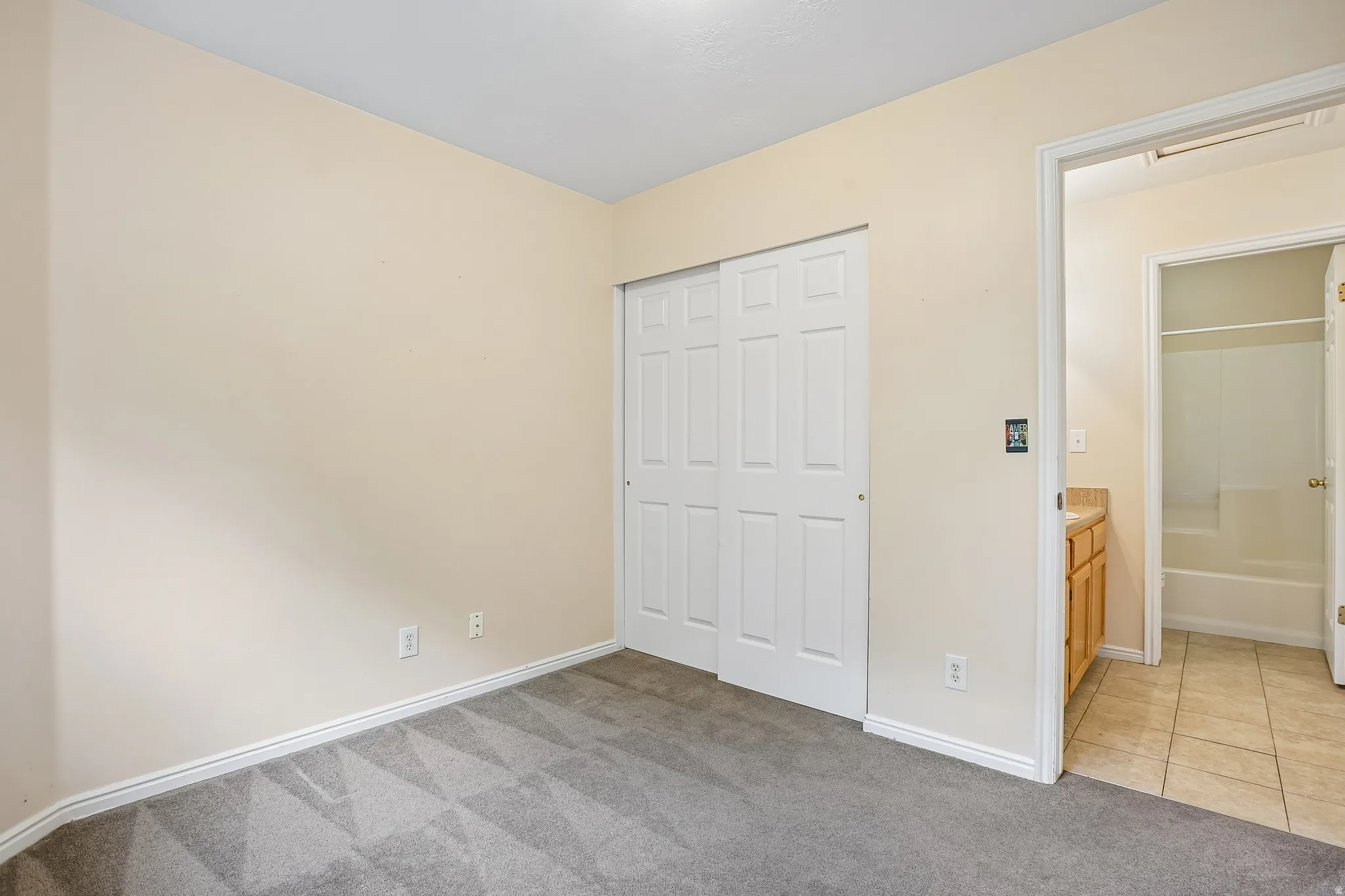 Bedroom featuring neutral wall paint, gray patterned carpeting, and white baseboards