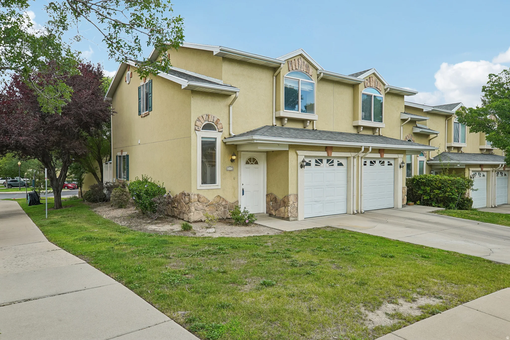 Cream-colored stucco exterior featuring stone accents and arched window details