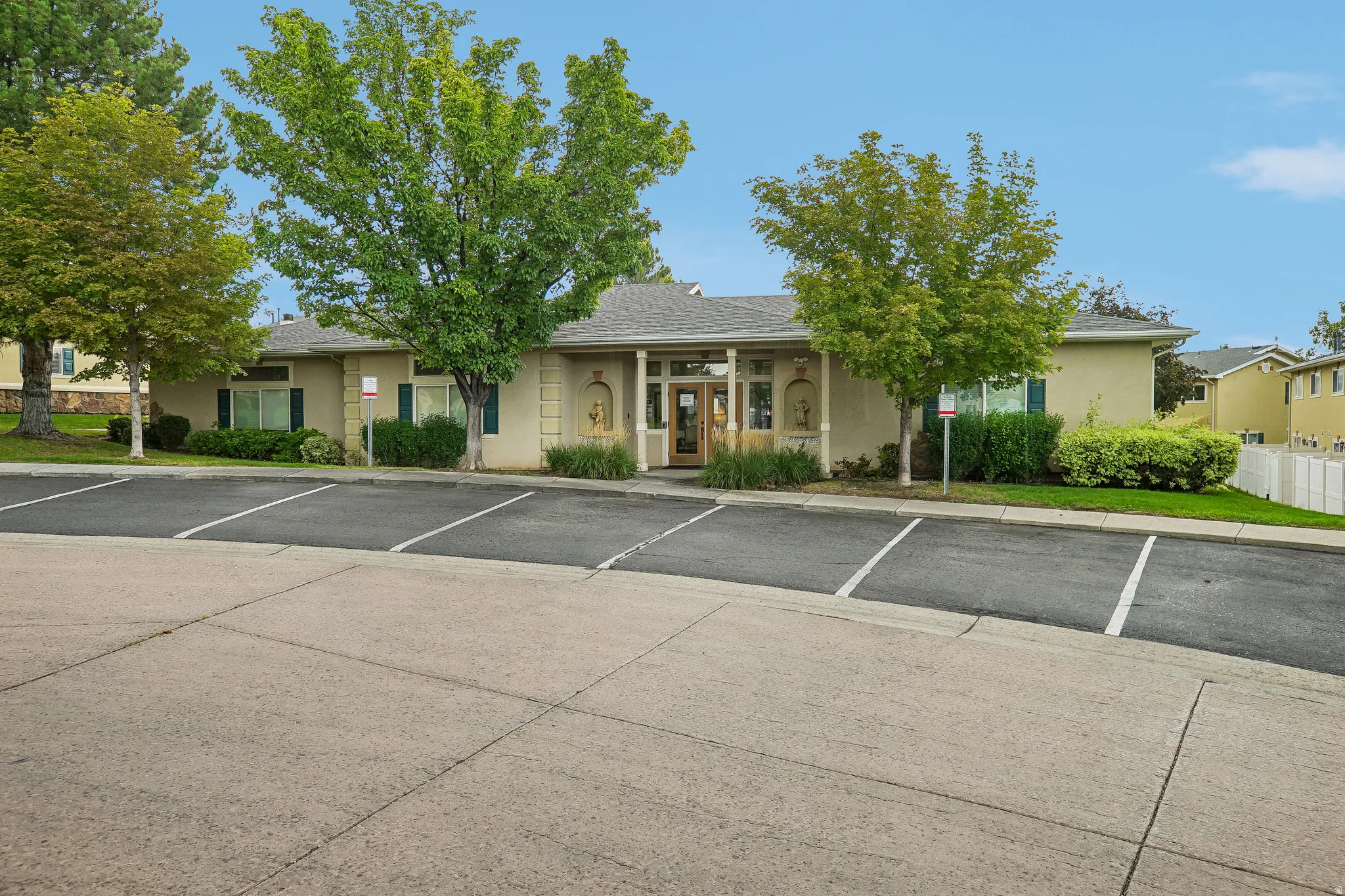 Paved parking area with marked spaces fronting a stucco-finished building
