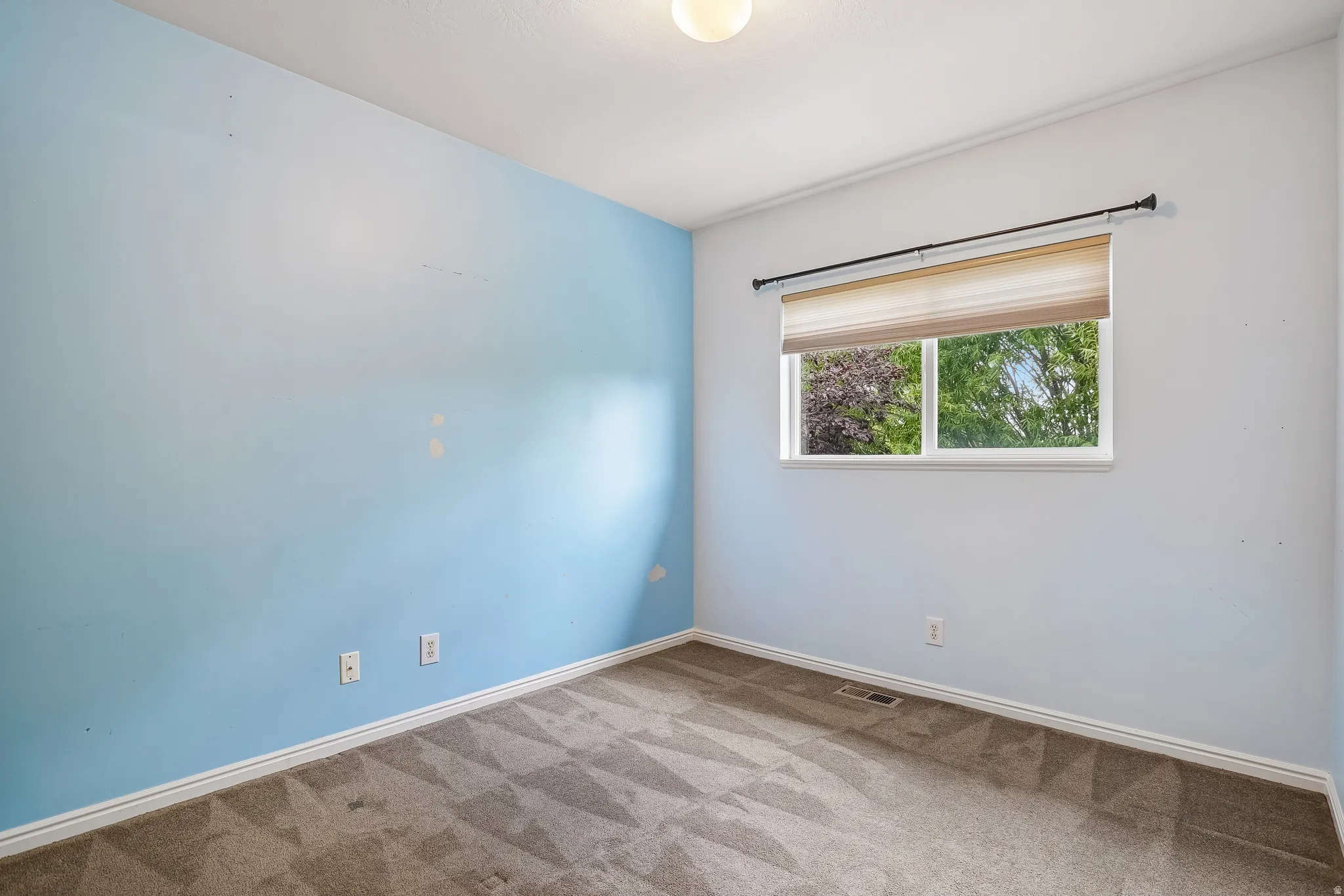 Light-filled room featuring a single window, recessed lighting, and carpeted flooring