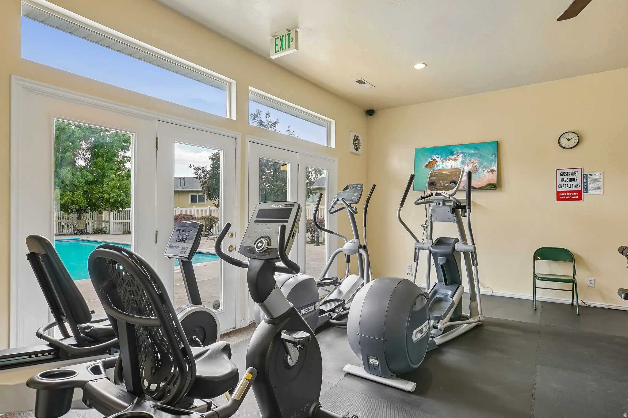 Fitness center featuring multiple exercise machines, rubberized flooring, and recessed lighting