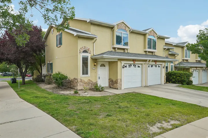 Cream-colored stucco exterior featuring stone accents and arched window details