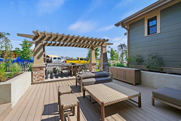 Outdoor patio featuring composite decking and a pergola with brick-accented columns
