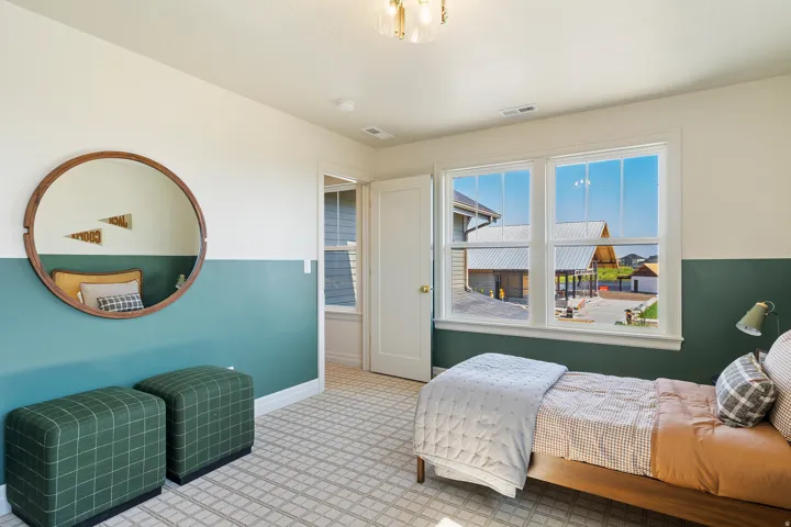 Bright room featuring large windows, two-tone wall treatment, and a patterned carpet