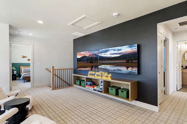 Carpeted loft area featuring a dark accent wall, recessed lighting, and a built-in media console