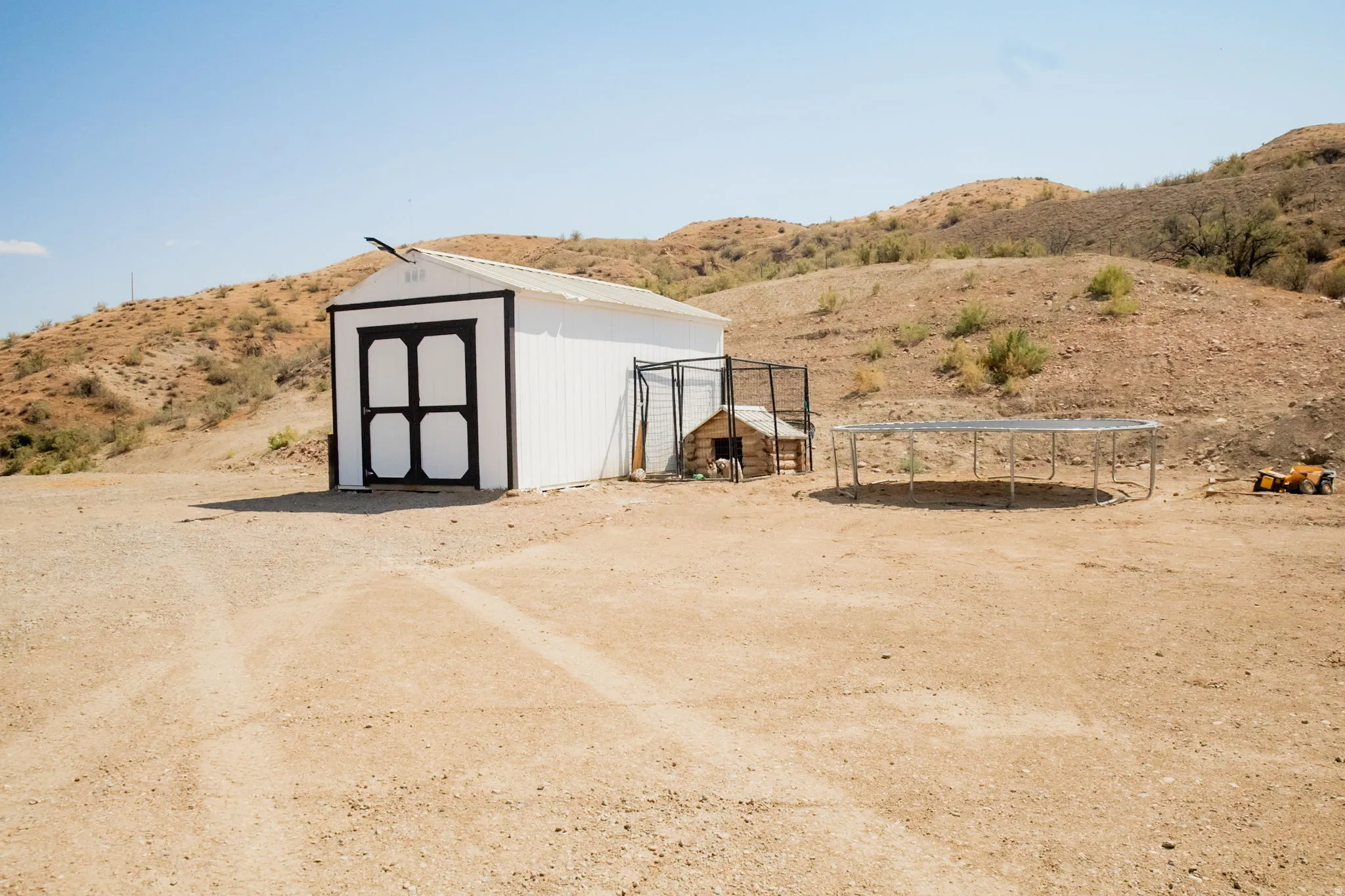 White exterior shed with black trim and double doors