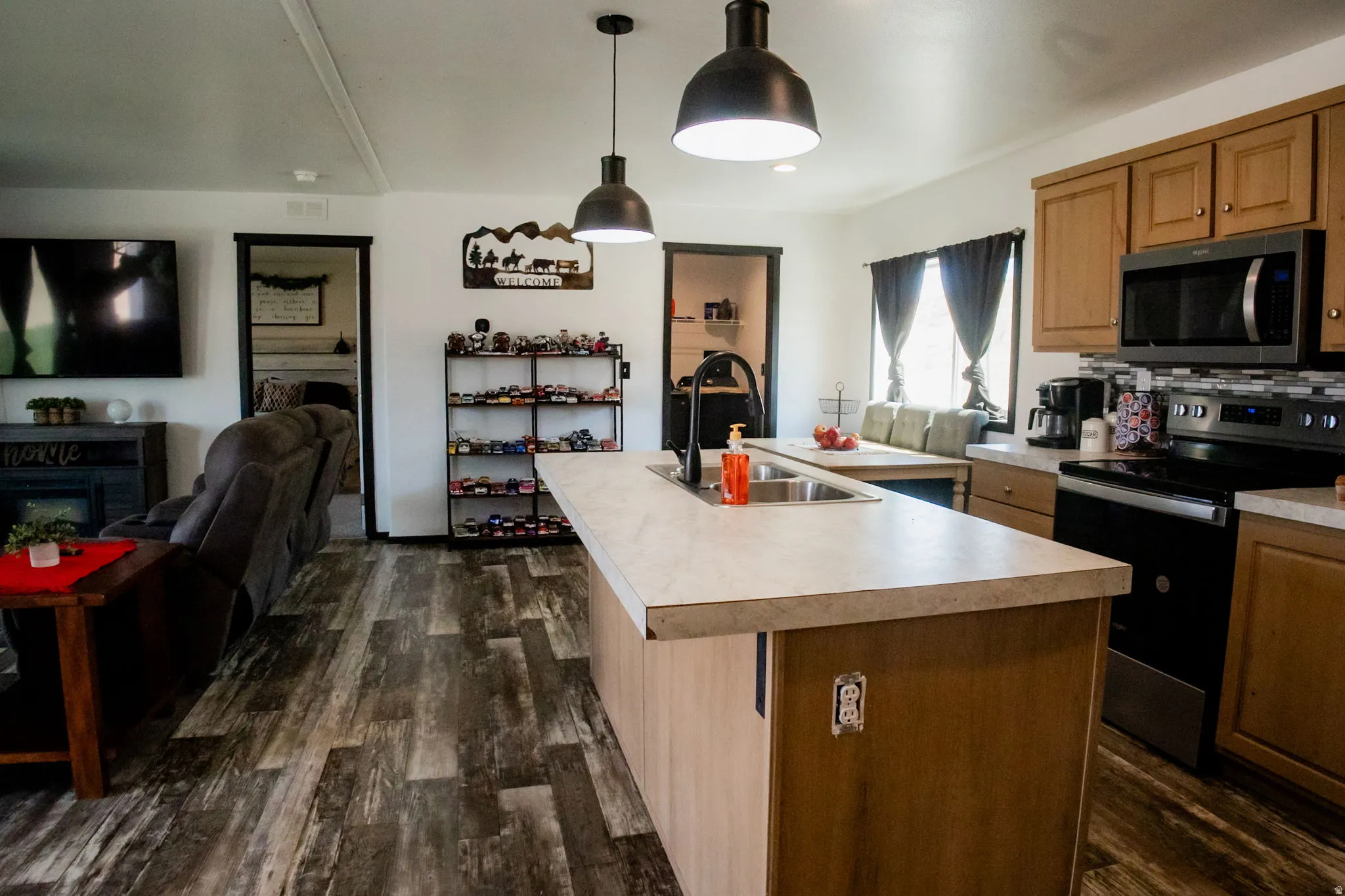 Kitchen island with an undermount sink, a gooseneck faucet, and integrated power outlets