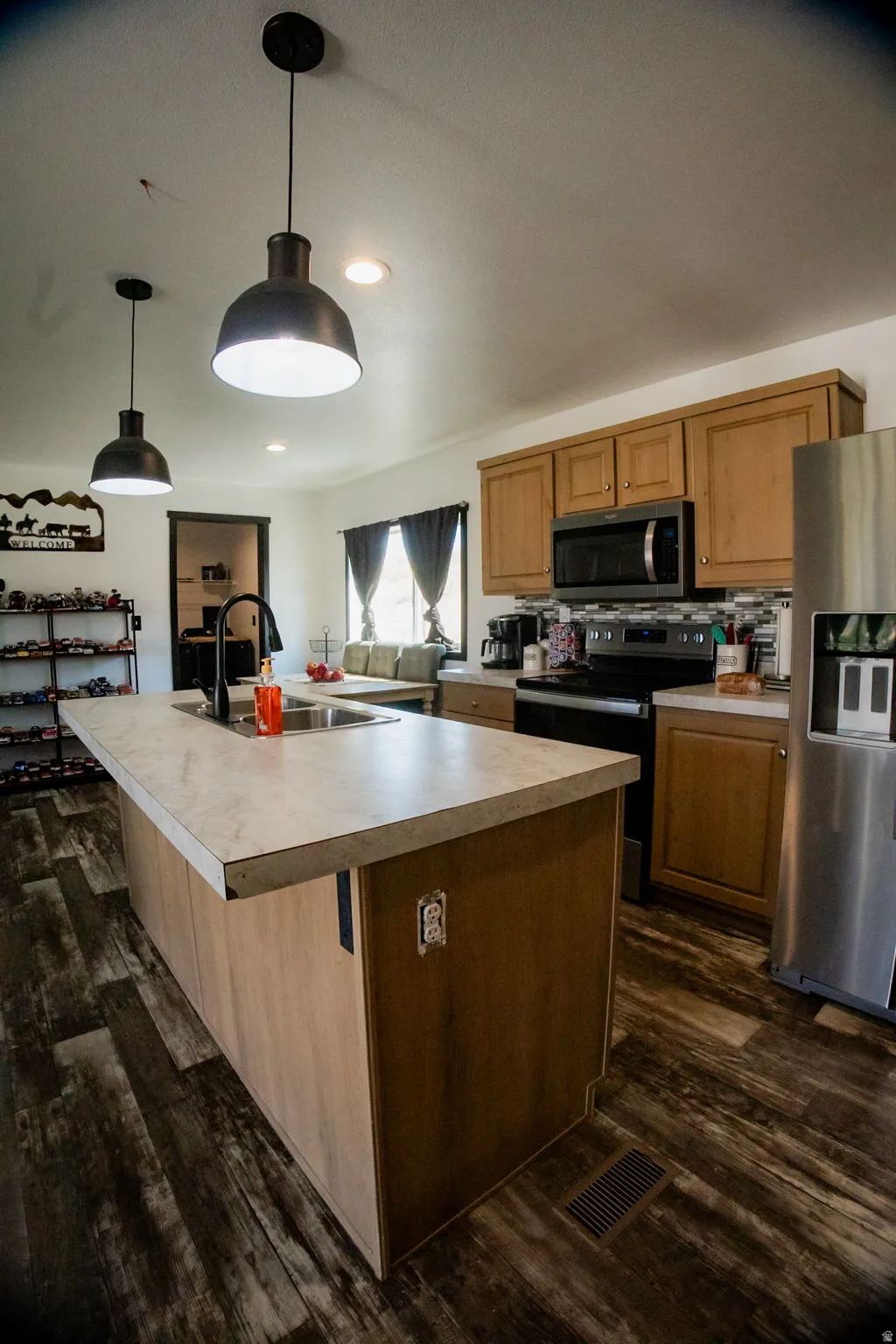 Kitchen island with an undermount sink, a gooseneck faucet, and two industrial-style pendant lights