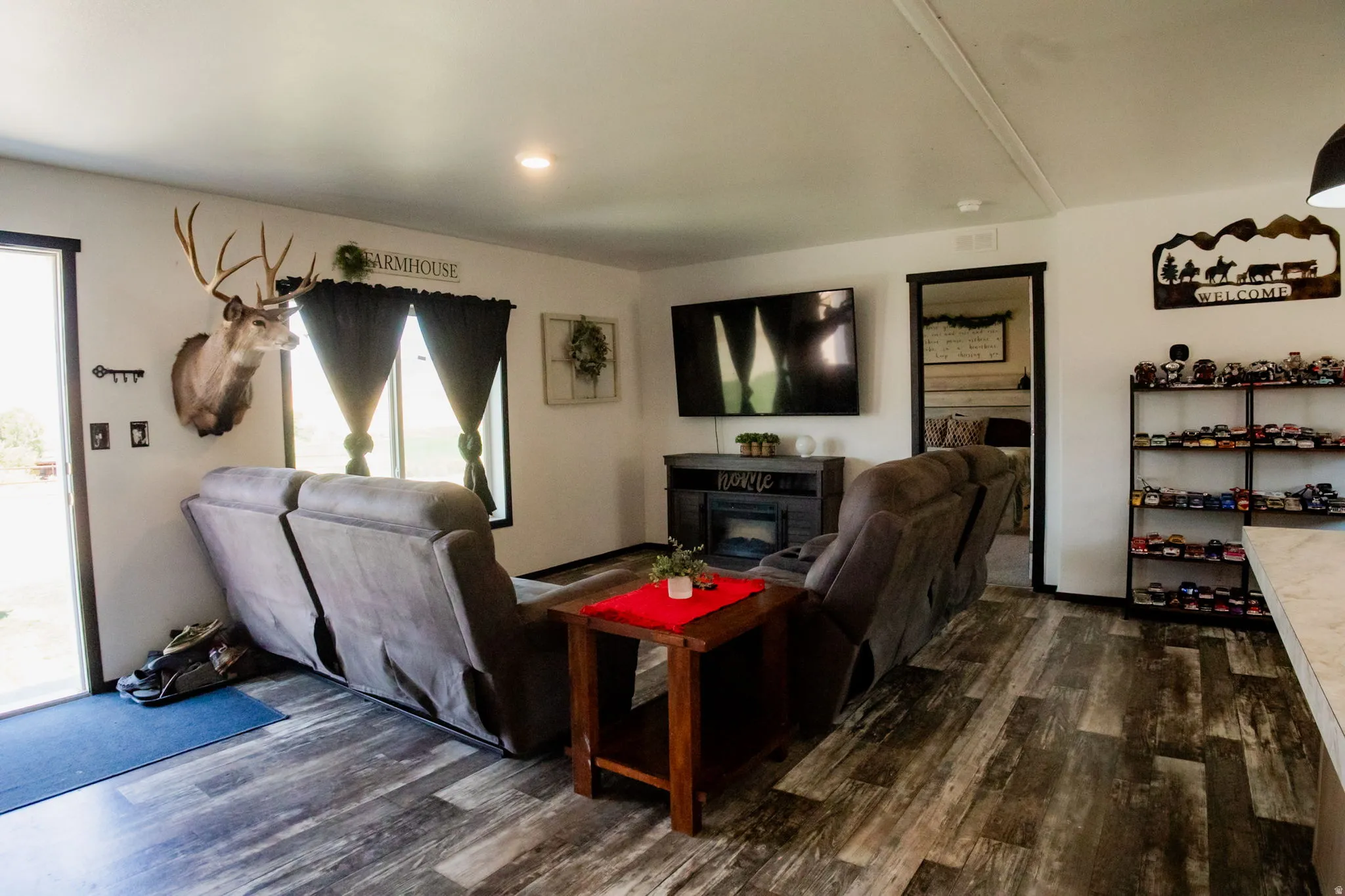 Living area featuring wood-finish flooring, recessed lighting, and white walls