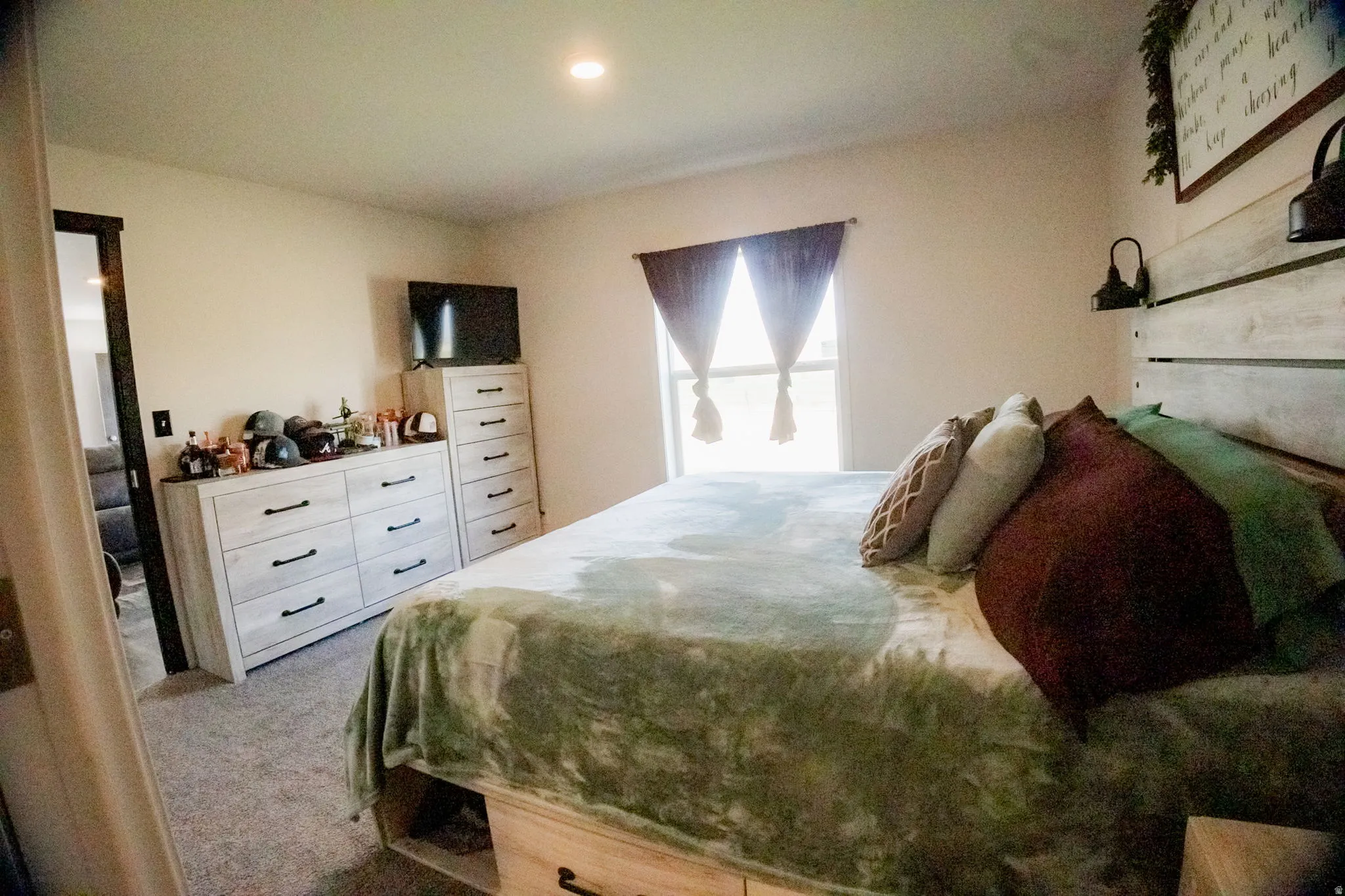 Recessed ceiling lighting, a window with dark drapery, and neutral wall paint