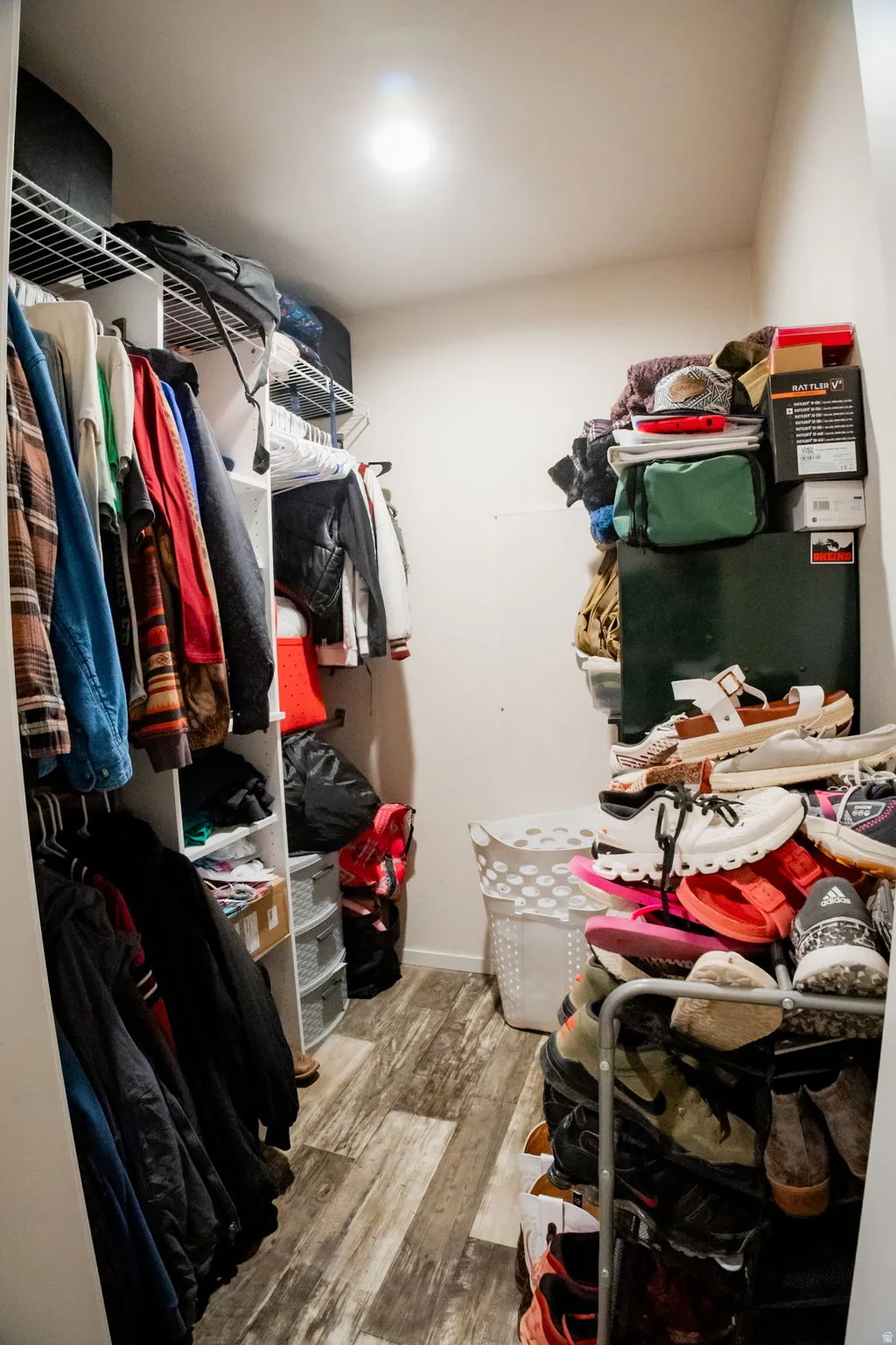 Walk-in closet featuring wood-finish flooring and recessed lighting