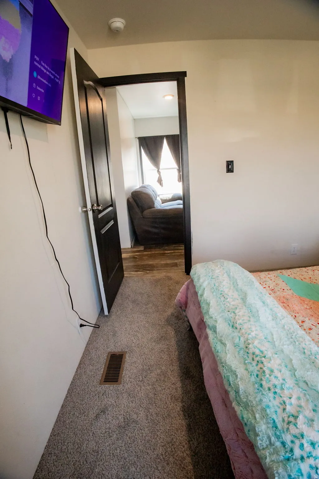 Room featuring light gray carpet flooring and a dark wood-finish door frame