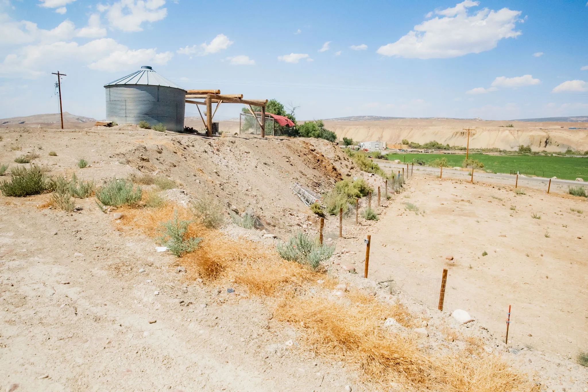 Grain silo structure on a rugged landscape, featuring a metal roof and support beams