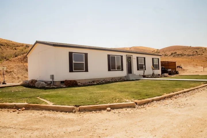 Single-story residence featuring white siding and dark trim windows