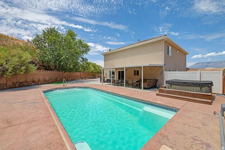 Rectangular swimming pool with a tile border and concrete decking