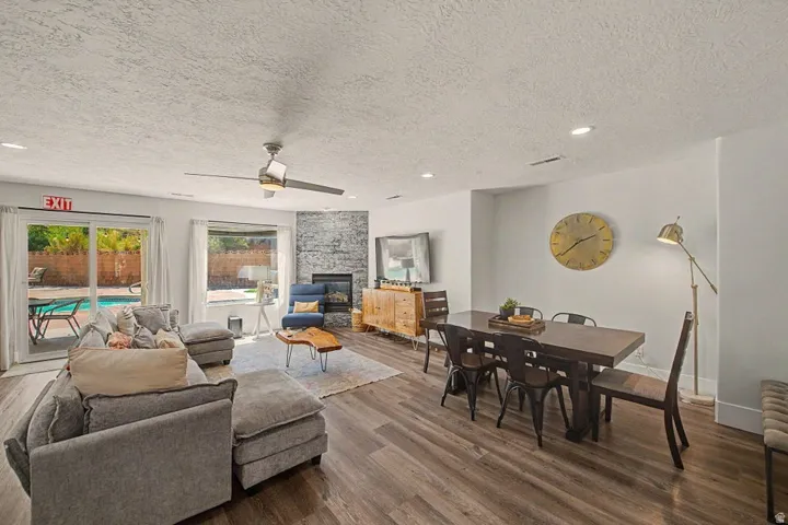 Spacious interior featuring wood-finish flooring, a contemporary ceiling fan, and recessed lighting