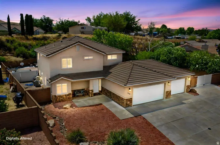 Contemporary two-story residence with a stucco exterior, stone accents, and a tile roof