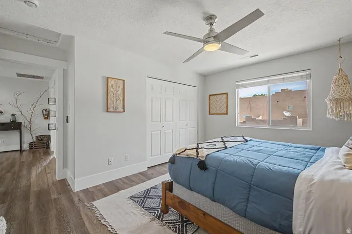 Bedroom featuring wood-finish flooring, a contemporary ceiling fan, and a double bi-fold closet
