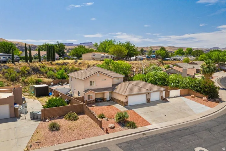 Two-story residence featuring a two-car garage, tile roof, and a low-maintenance xeriscaped front yard