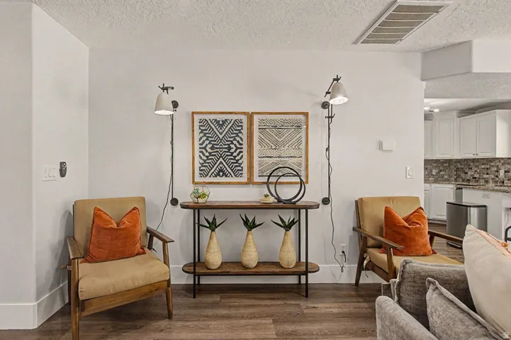 Open-concept living space with wood-finish flooring, white baseboards, and a neutral wall palette