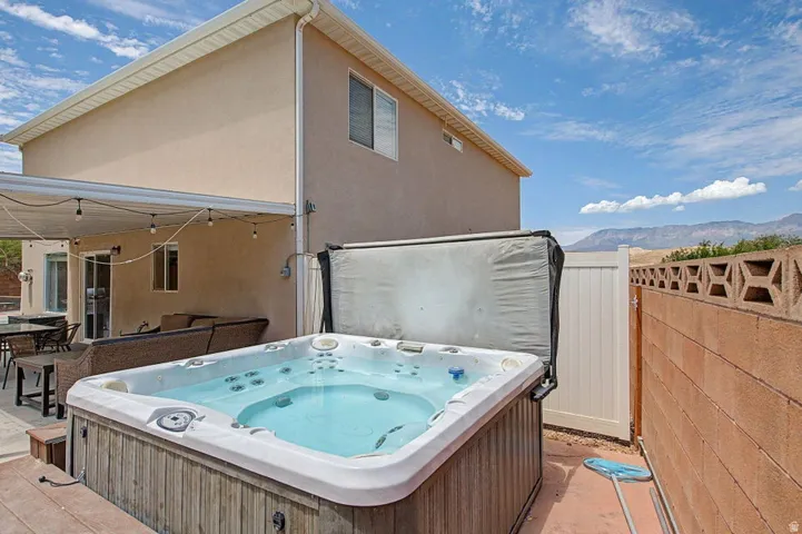 Outdoor spa with a wood-finish surround on a concrete patio
